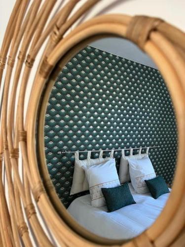a reflection of a bed with pillows in a mirror at SPACIEUSE MAISON DE VILLE avec garage privé fermé in Ay