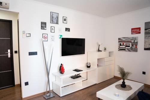 een witte woonkamer met een tv aan een witte muur bij Rovigno tesoro 1 in Rovinj