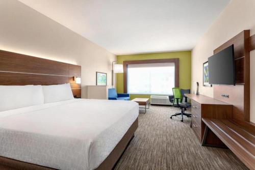 a hotel room with a large bed and a flat screen tv at Holiday Inn Express & Suites Austin North - Pflugerville by IHG in Pflugerville