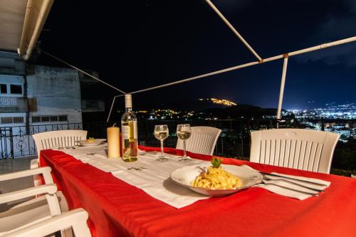 a table with a plate of food and wine glasses at Nikolas apartment II in Nafplio