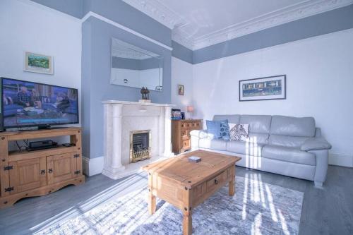 a living room with a couch and a fireplace at Seaways Holiday Home, Ocean Road, South Shields. in South Shields