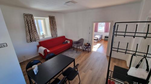 a living room with a red couch and a table at Klein und Fein in Windischgarsten