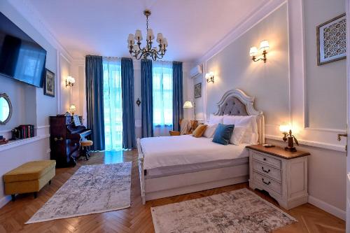 a bedroom with a white bed and a chandelier at Casa Barițiu in Braşov