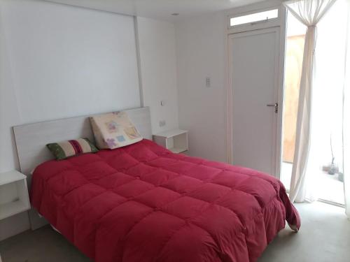 1 dormitorio con un gran edredón rojo en una cama en Mussa en Salta