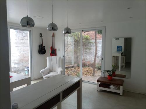 sala de estar con mesa, silla y ventana en Mussa en Salta