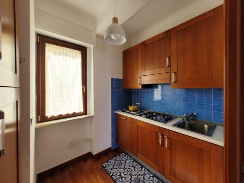 a kitchen with wooden cabinets and a sink and a window at Sara blu apartment in Sorrento