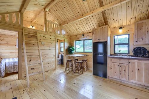 a log cabin kitchen and dining room with a black refrigerator at Down the Shore Campground in Ocean View