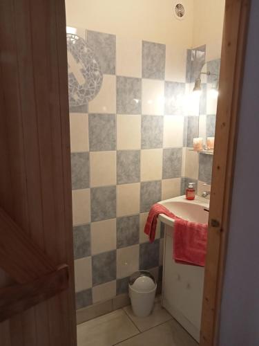 a bathroom with a sink and a tiled wall at La maison neuve in Fontaines