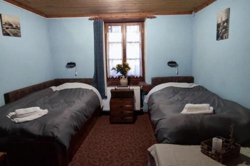 a bedroom with two beds and a window and a table at COZY VILLAGE HOUSE ΑΓΙΟΣ ΛΑΥΡΕΝΤΙΟΣ ΠΗΛΙΟΥ in Agios Lavrentios