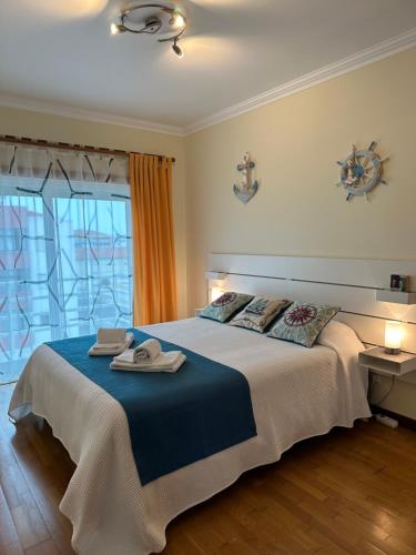 a bedroom with a large bed with towels on it at Sun & Wave Apartment in Peniche