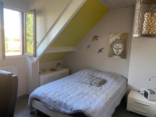 um pequeno quarto com uma cama e uma escada em Laetisteph em Neuilly-sur-Marne