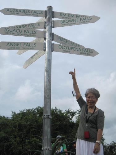 a woman standing next to a street sign with arrows at Meander In in Howick