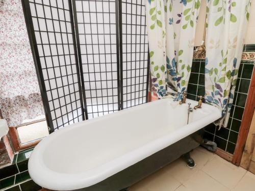 a white bath tub in a bathroom with a shower curtain at Bolland Hall in Morpeth