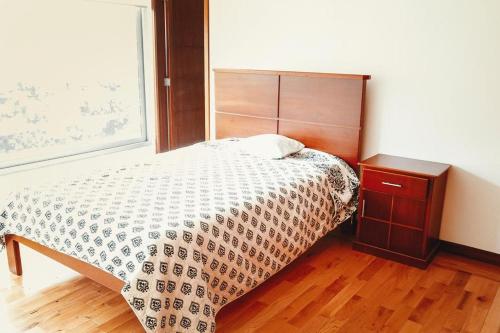 - une chambre avec un lit et une tête de lit en bois dans l'établissement RESIDENCIA LOLITA, à Santa Isabel