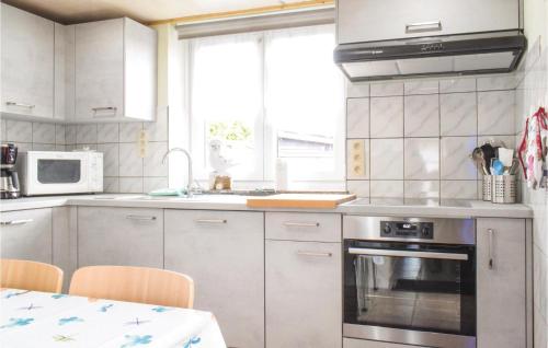 a kitchen with white cabinets and a sink and a stove at Jessica in Ciney