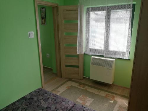 a green room with a window and an air conditioner at Ubytovanie v súkromí Zelený dom in Vyšné Ružbachy