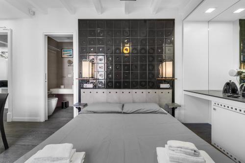 a bedroom with a large bed and a kitchen at Ukiyo Suites And Rooms in Cagliari