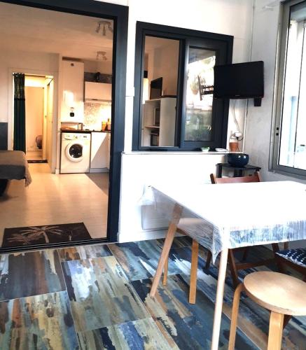Il comprend un salon avec une table blanche et une cuisine. dans l'établissement T2-3 cabine Les YUCCAS 200 m plage du Boucanet Rive Droite Grau du Roi idéal 2-4 pers, au Grau-du-Roi