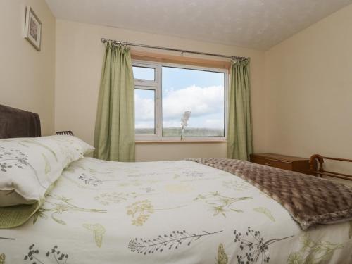 a bedroom with a bed and a window at Underlanes in Camelford