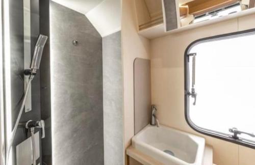 a small bathroom with a sink and a mirror at Campervan and Motorhome Hire Isle of Man in Kirk Braddon