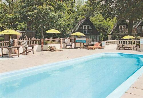 una piscina con sillas, mesas y sombrillas en Tamar Valley, Cornwall, en Callington