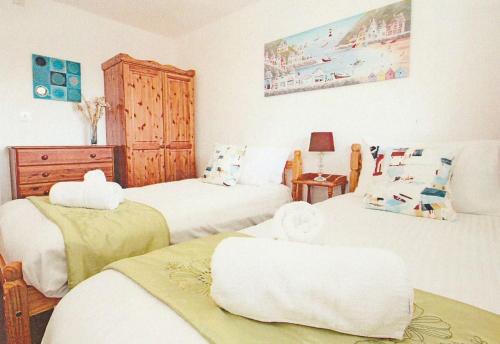 a bedroom with two beds with white sheets at Tamar Valley, Cornwall in Callington