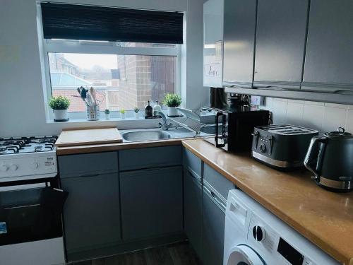 a kitchen with a sink and a stove top oven at Hotel 3H in Stafford