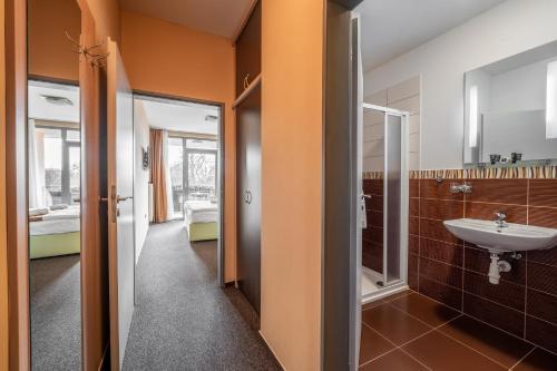 ein Bad mit einem Waschbecken und einem Spiegel in der Unterkunft Penzion a Restaurant Barbora in Kutná Hora