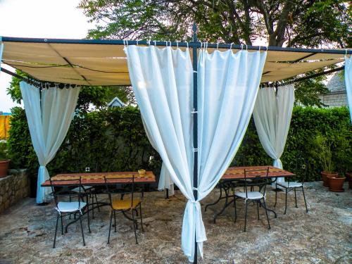 a group of tables and chairs under a canopy at Agriturismo Masseria Calongo in Cisternino