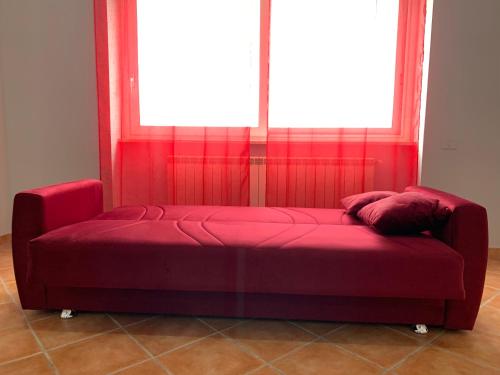 a red couch in a room with a window at Casa Vacanze Formia in Formia