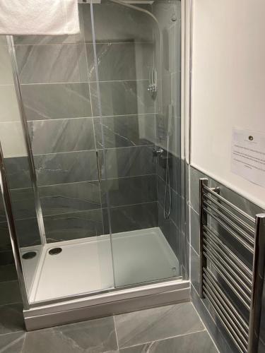 a shower with a glass door in a bathroom at Victoria House Bed and Breakfast in Fort William