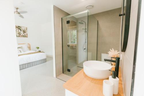 a bathroom with a sink and a glass shower at Tinarra Treetops in Maroochy River