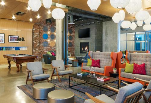 a lobby with couches and chairs and a fireplace at Aloft by Marriott Louisville Downtown in Louisville