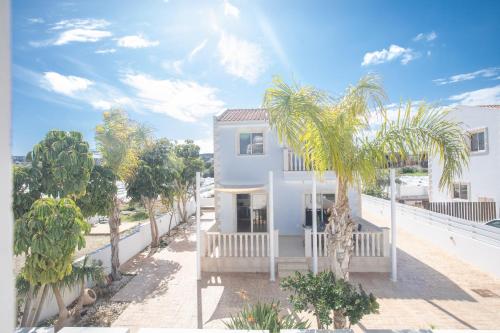 una casa blanca con palmeras delante en Tonia Seaview Villas, en Protaras
