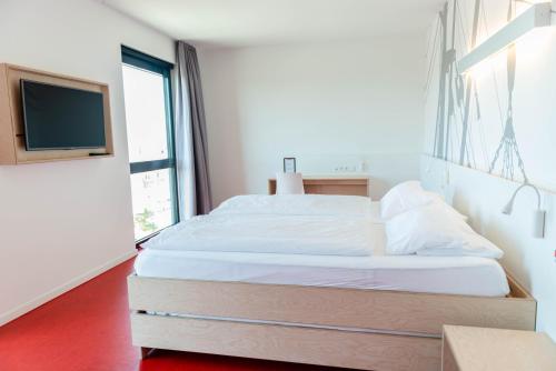 a bedroom with a large bed and a tv at havenhostel Cuxhaven in Cuxhaven