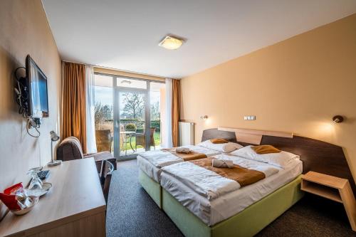 a bedroom with a large bed and a large window at Penzion a Restaurant Barbora in Kutná Hora