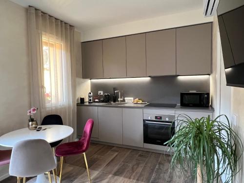 a kitchen with white cabinets and a table and chairs at DR54 Apartments in Rho