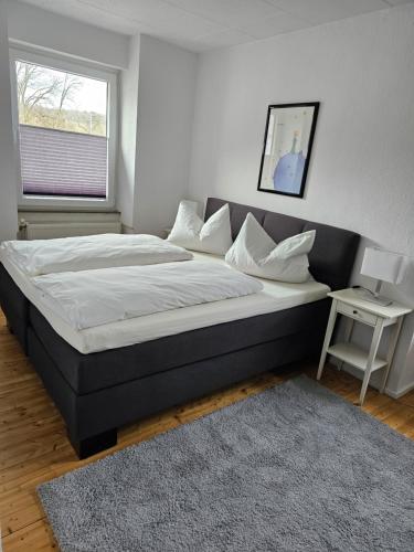 Cette chambre comprend un grand lit et une fenêtre. dans l'établissement Große Ferienwohnung in Koblenz, à Coblence