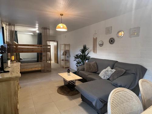 uma sala de estar com um sofá e uma cama em Apartamento loft, jardín y piscina privada em Romanyá de la Selva