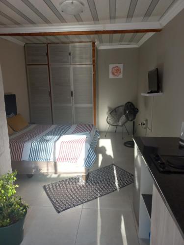 um pequeno quarto com uma cama e uma cozinha em Comfort place 2 em Pretoria