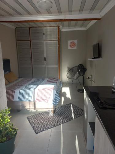 プレトリアにあるComfort place 2の小さなベッドルーム(ベッド1台付)、キッチンが備わります。