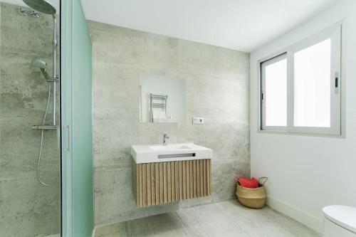 y baño con lavabo y ducha. en Moderno y completo apartamento frente al mar en Málaga