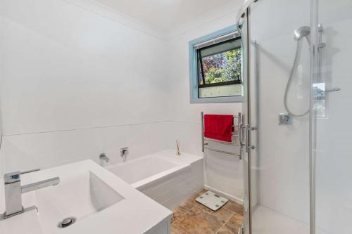 a bathroom with a tub and a sink and a shower at Spa, Stay & Holiday in Rotorua