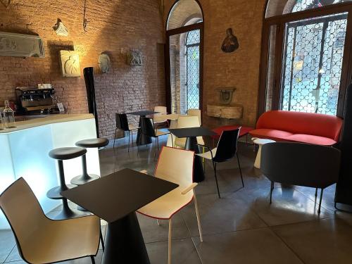 a restaurant with tables and chairs in a room at Palazzetto Rosso - Art Hotel in Siena