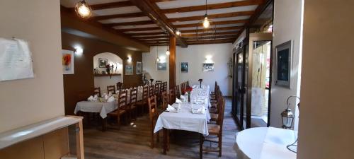 Saint-Clement-sur-ValsonneにあるHôtel Restaurant Le Saint Clémentのレストラン内のダイニングルーム(テーブル、椅子付)