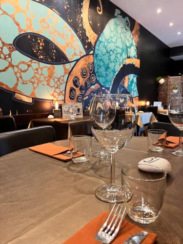 une table dans un restaurant avec des verres à vin dessus dans l'établissement Les Enfants Terribles, à Villeneuve-lès-Béziers