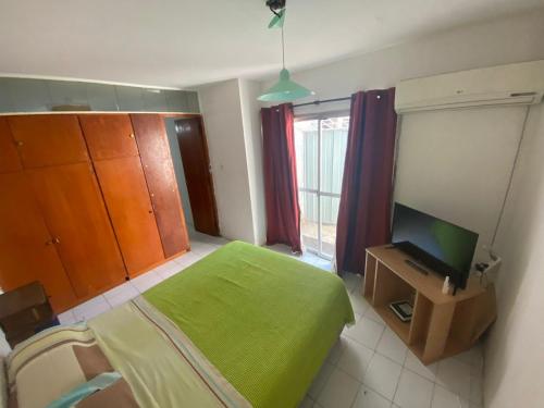 1 dormitorio con 1 cama verde y TV en Departamento Aristides en Mendoza