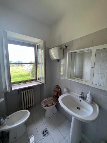 a white bathroom with a sink and a toilet at camere Rosignoli in Assisi