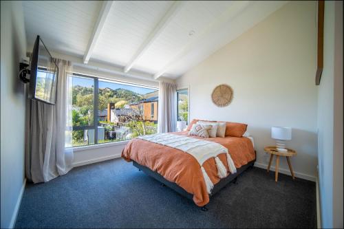 um quarto com uma cama e uma grande janela em City Apartments em Nelson