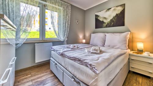 a small bedroom with a bed and a window at Apartament H7 - 5D Apartamenty in Świeradów-Zdrój